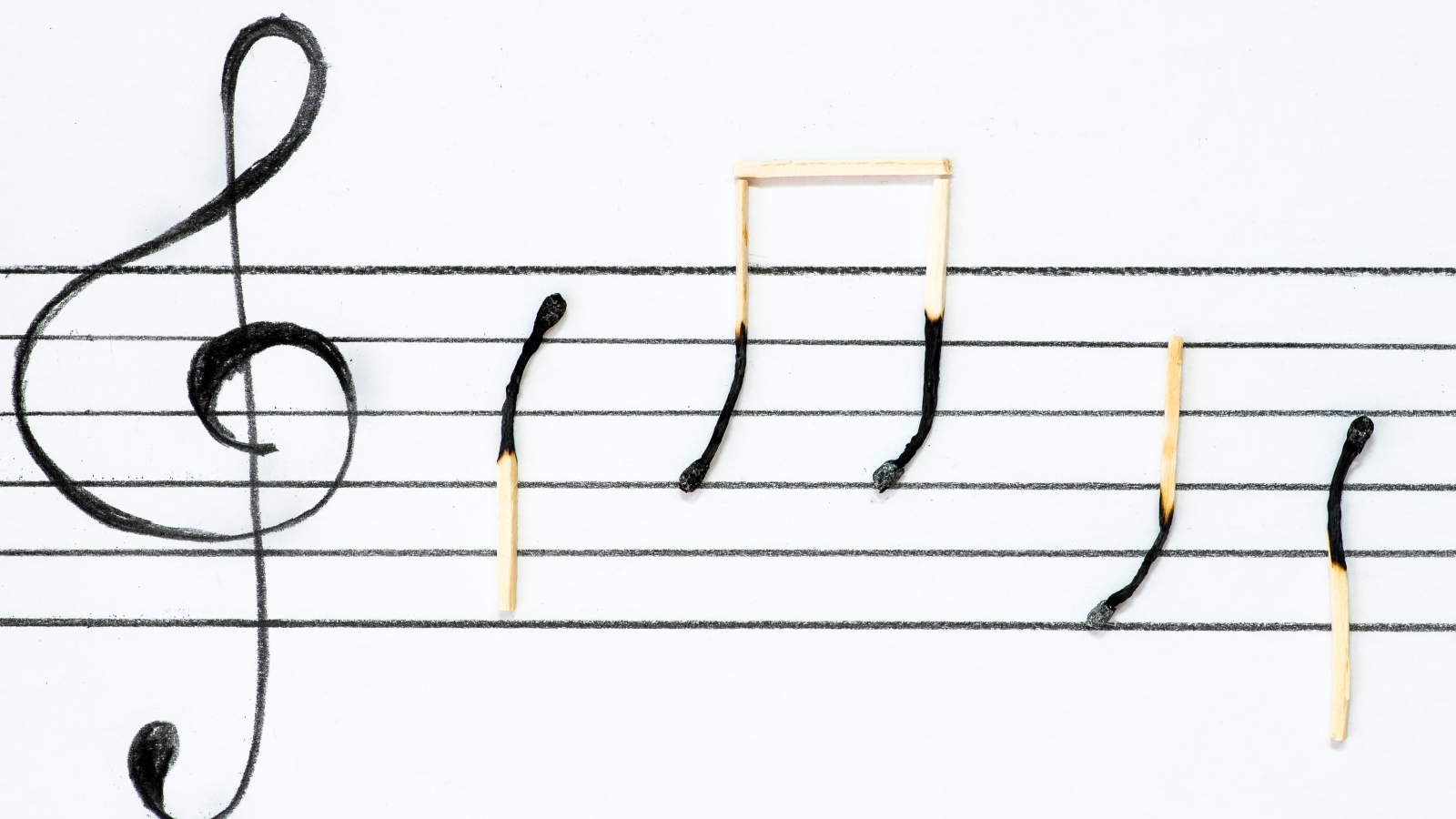 Ноты на белом фоне из сожженных спичек