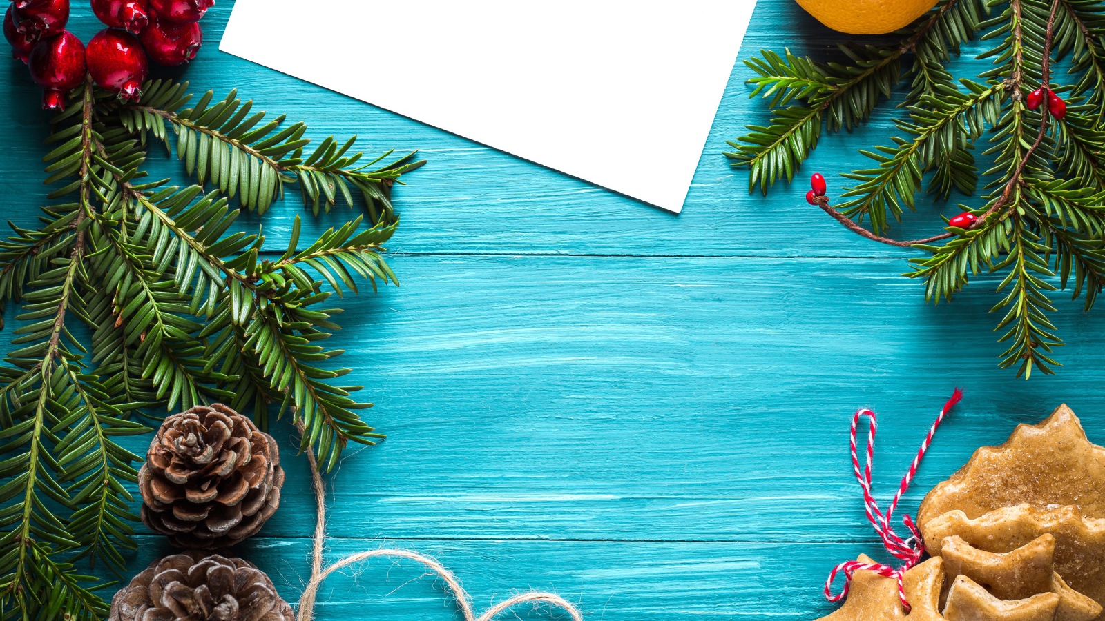 Еловые ветки с печеньем, шишками и декором на синем фоне