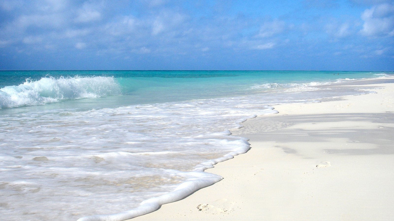 Чистый белый песок на пляже с голубой водой