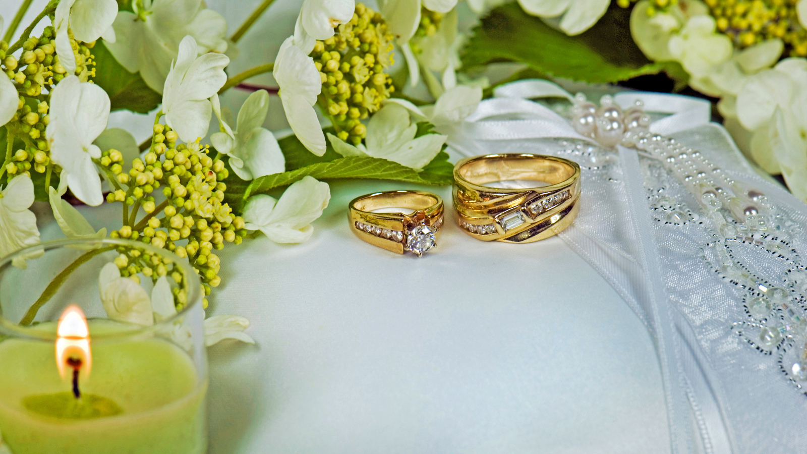 Два кольца с цветами и свечой на подушке 