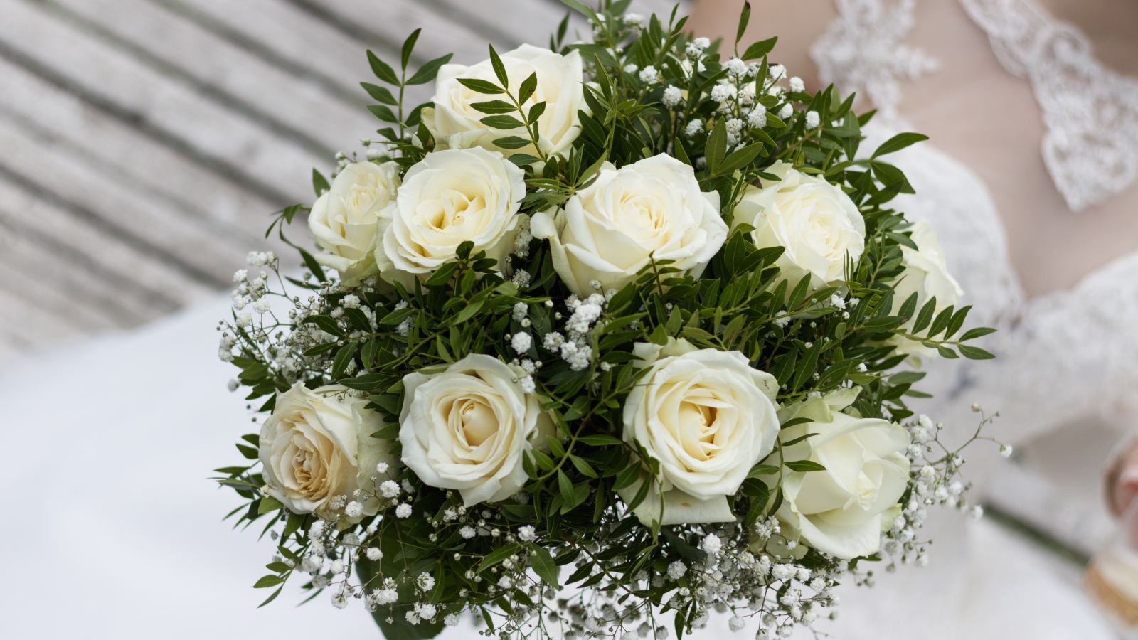 Свадебный букет белых роз в руке у невесты
