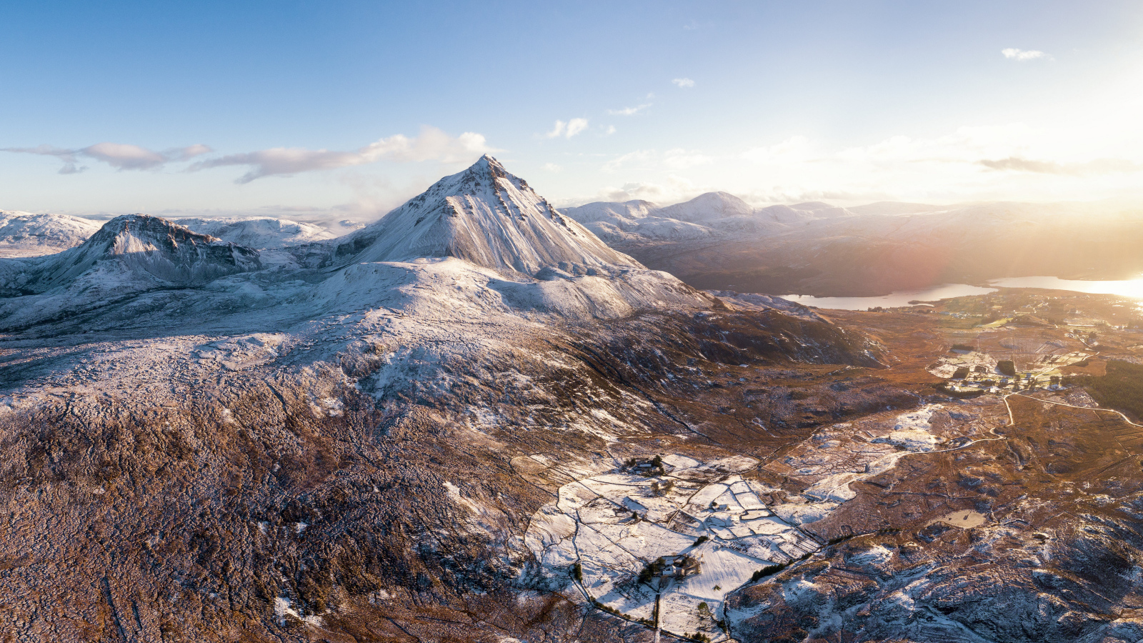 Вид на высокие заснеженные горы в лучах солнца