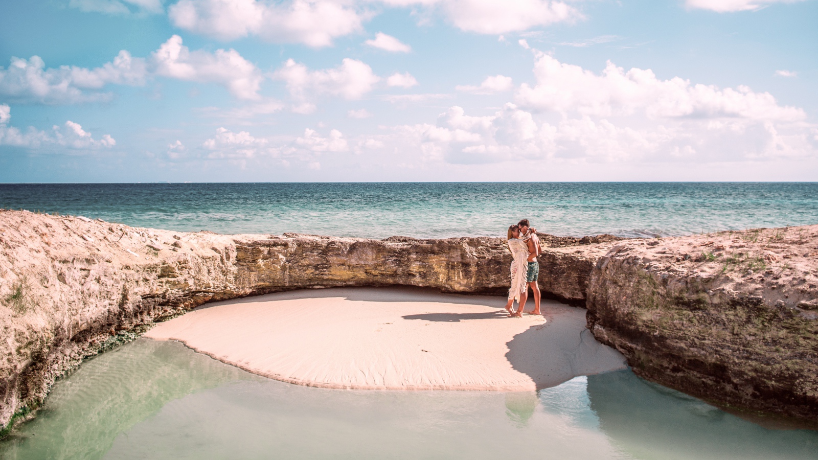 Каменное ограждение на морском пляже летом 
