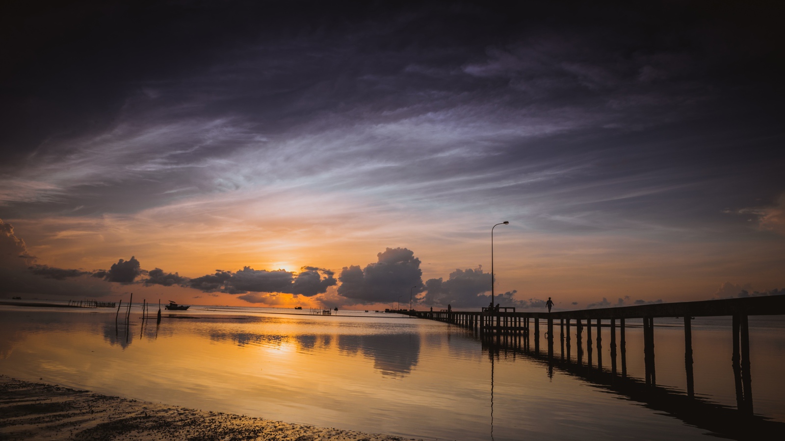 Деревянный мост на реке в лучах  солнца на закате