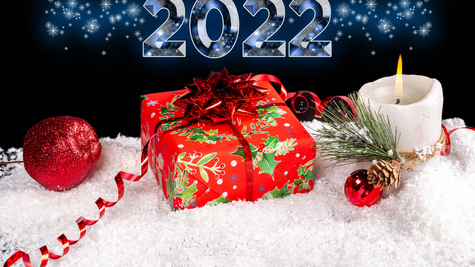 Подарок и свеча на снегу на новый год 2022 