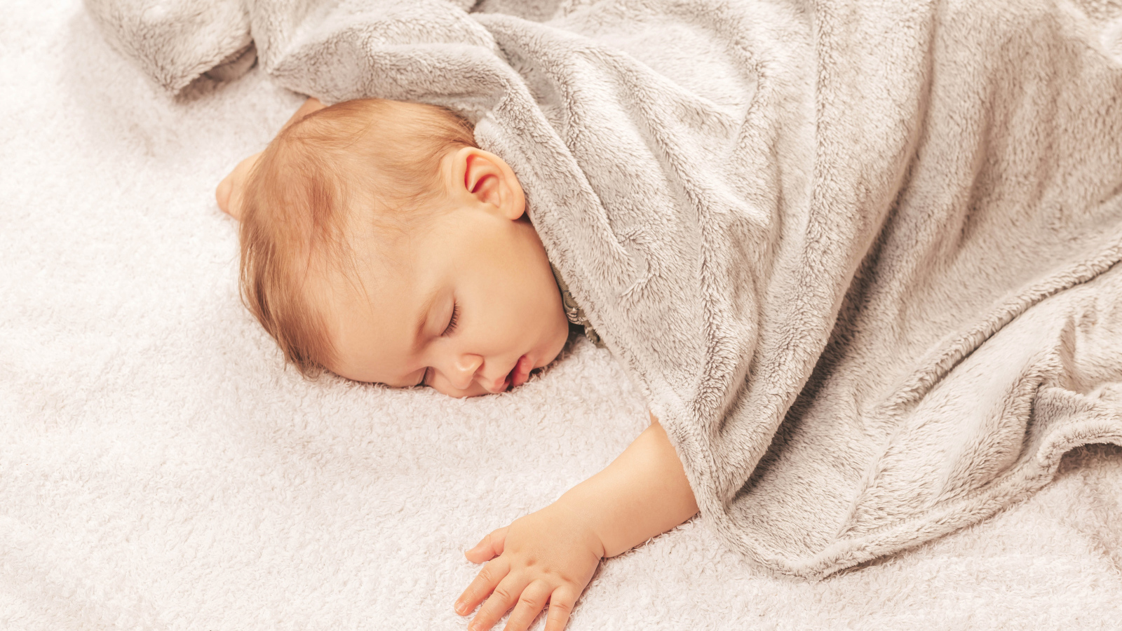 Грудной спящий ребенок под одеялом 