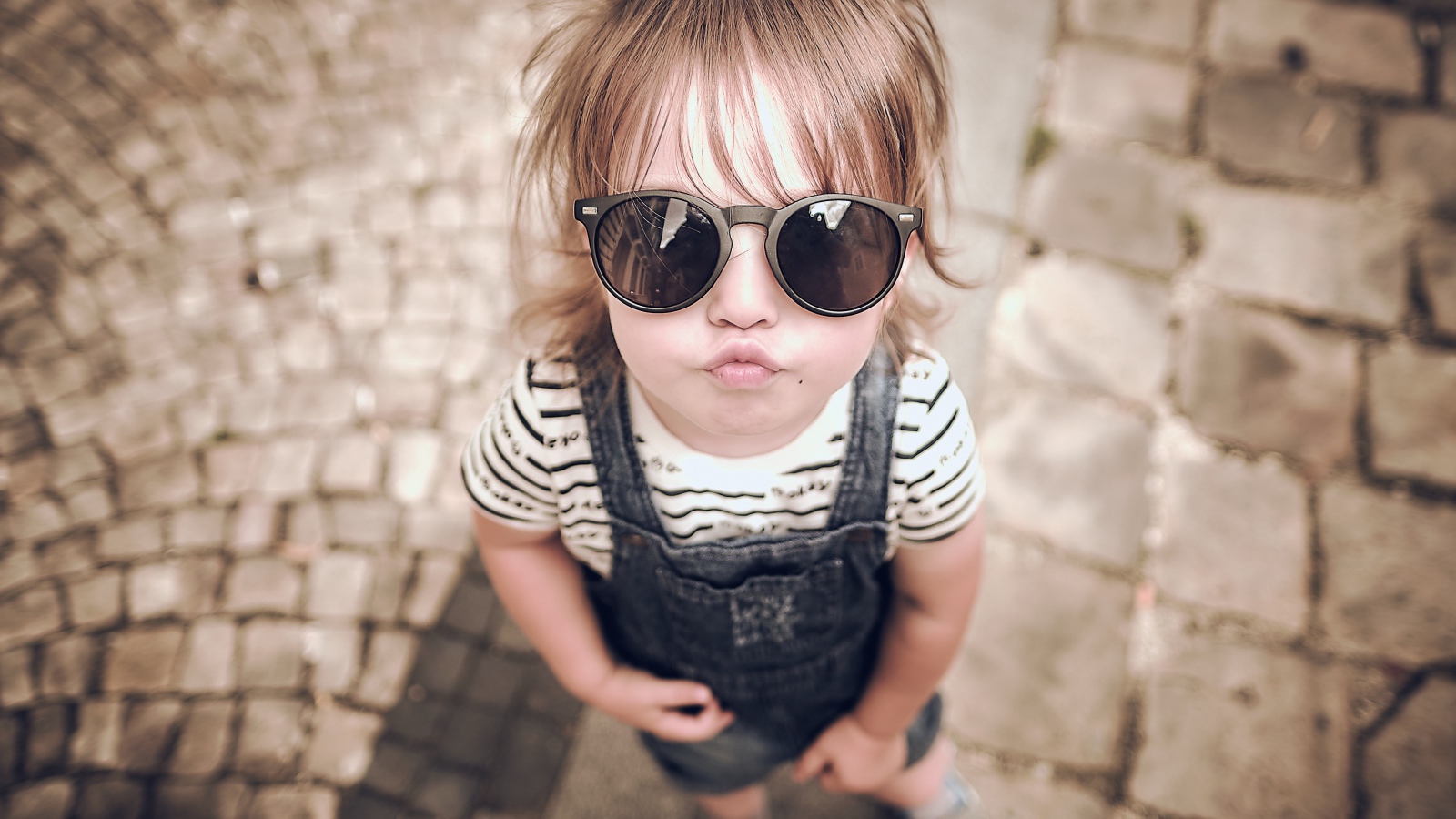 Модная маленькая девочка в черных очках