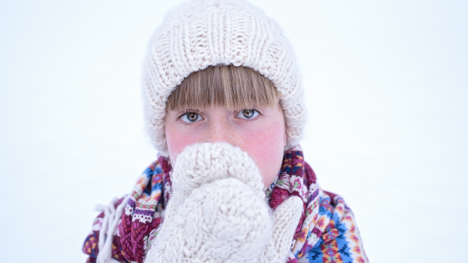 Девочка в рукавицах и белой шапке