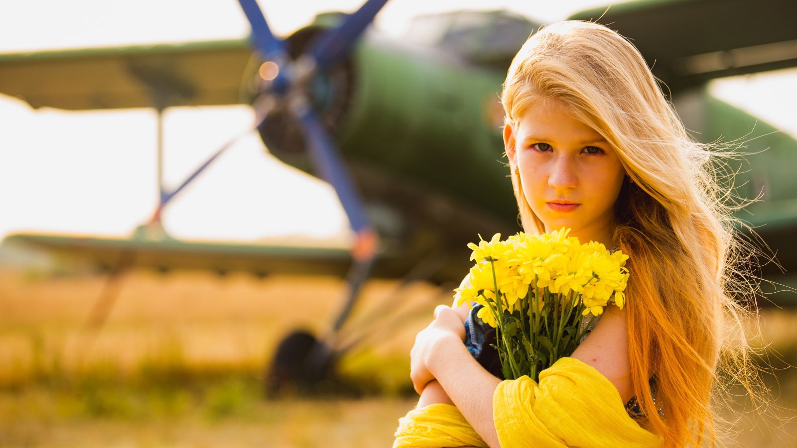 Девочка с букетом желтых хризантем у самолета 