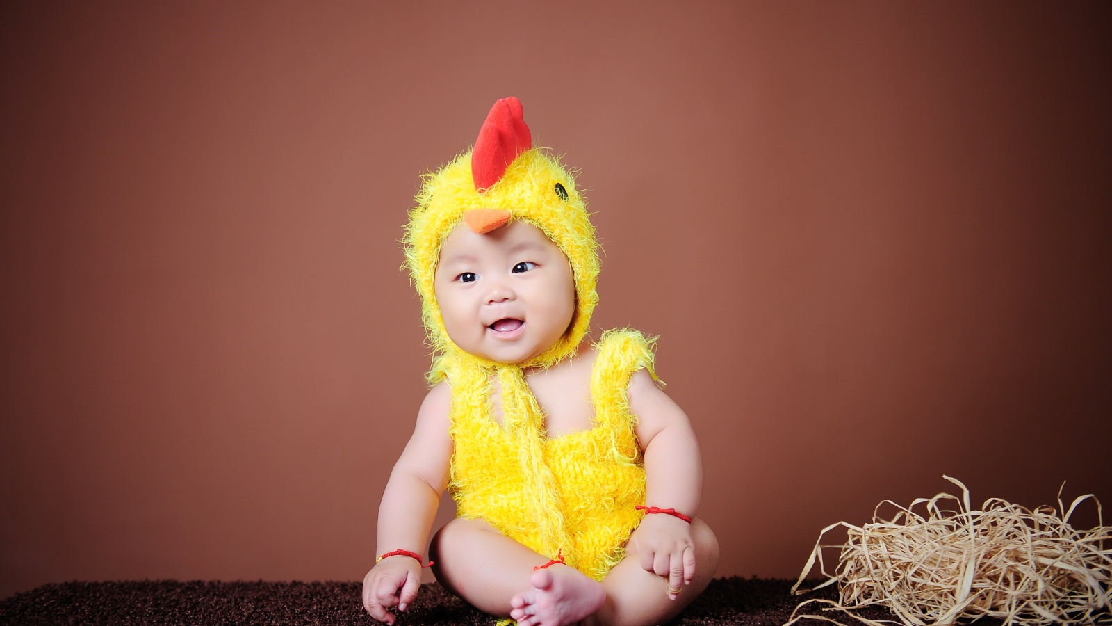 Маленький мальчик азиат в костюме цыпленка