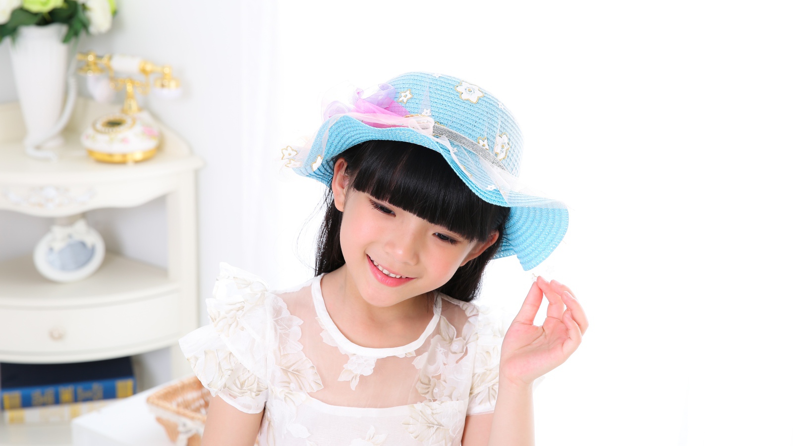 Маленькая девочка азиатка в белом платье 