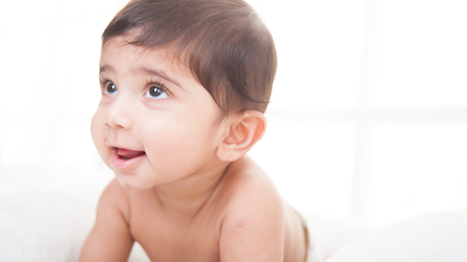 Маленький кареглазый мальчик на белом фоне 