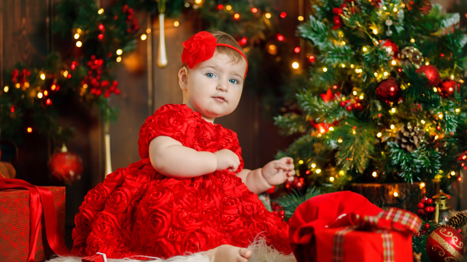 Маленькая девочка в красивом платье у наряженной ели 