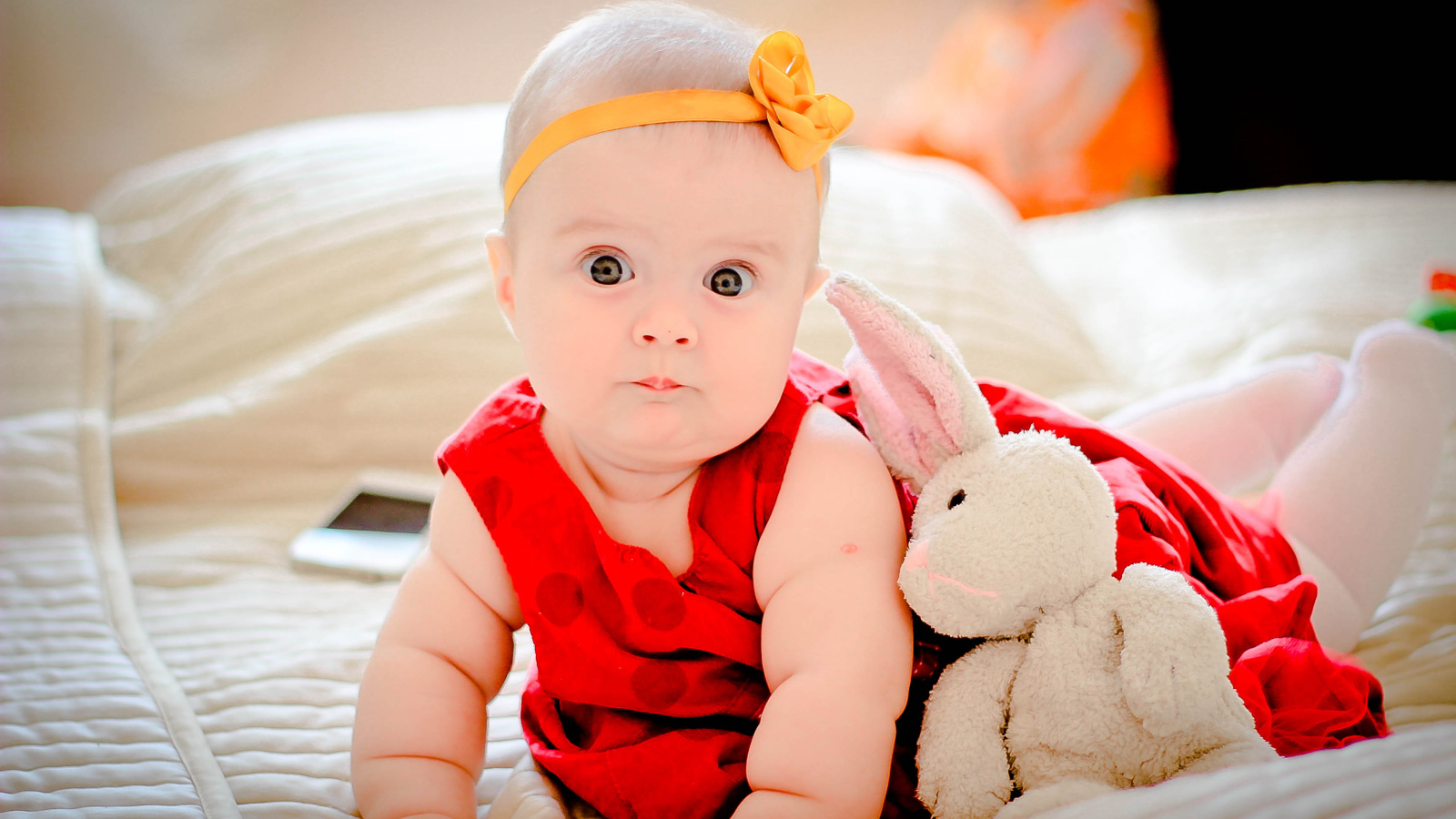 Маленькая девочка в красном платье с игрушкой 