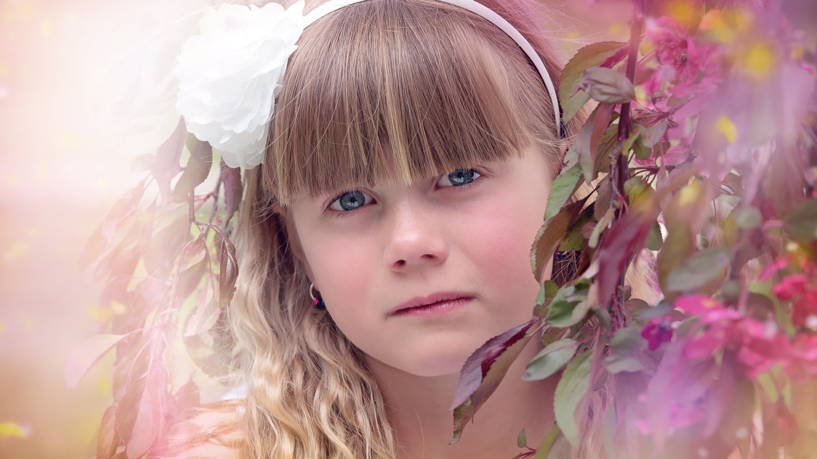 Грустная маленькая девочка у ветки дерева 