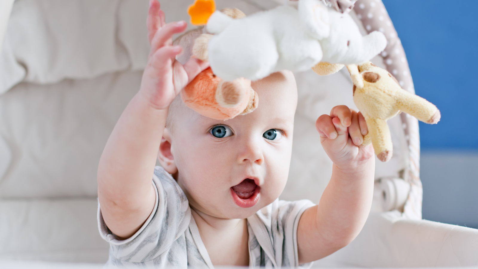 Маленький грудной ребенок в коляске с игрушками 