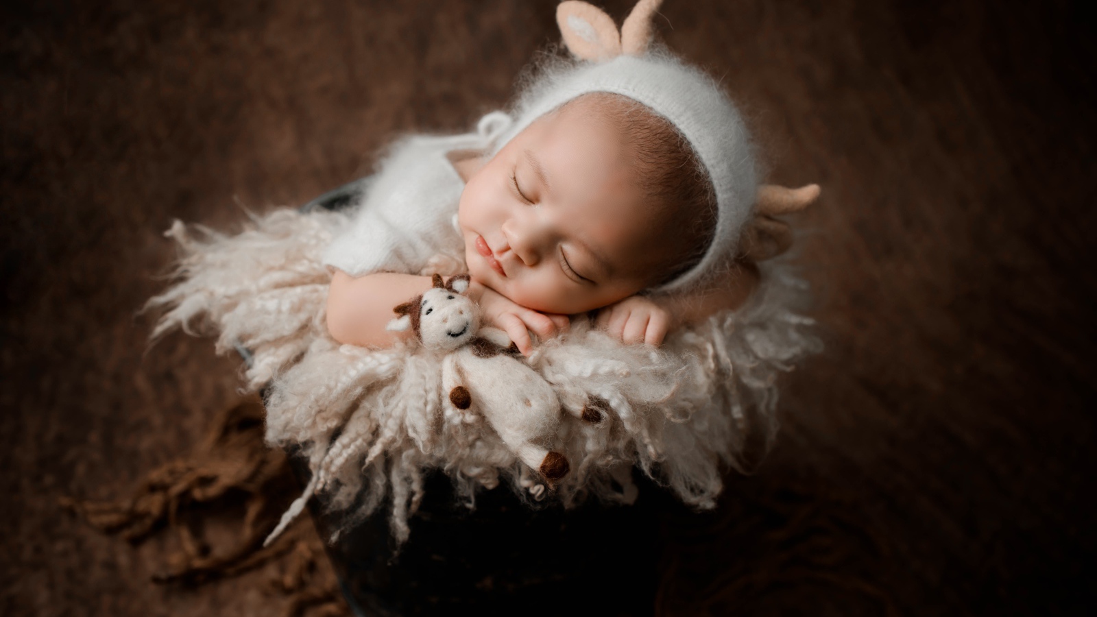 Маленький грудной ребенок спит в ведре