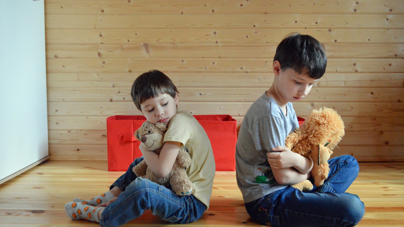 Два маленьких обиженных мальчика сидит на земле