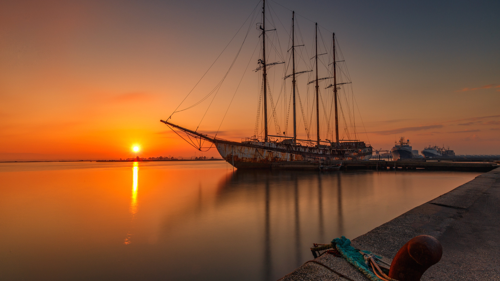 Большой корабль стоит на закате солнца 