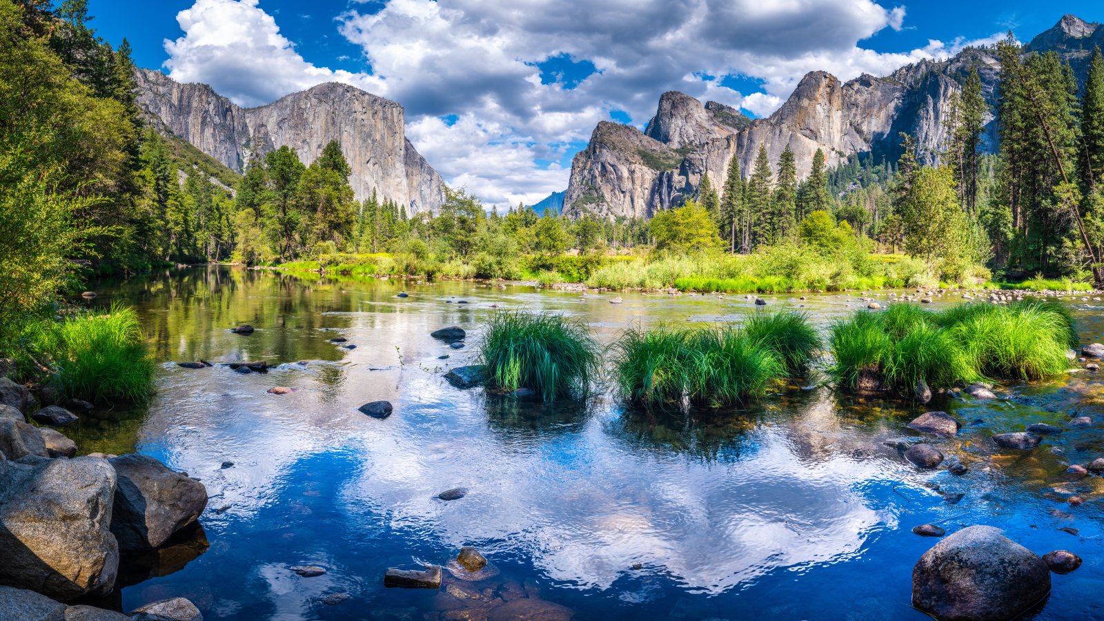 Спокойная вода в озере на фоне гор под белыми облаками, США 
