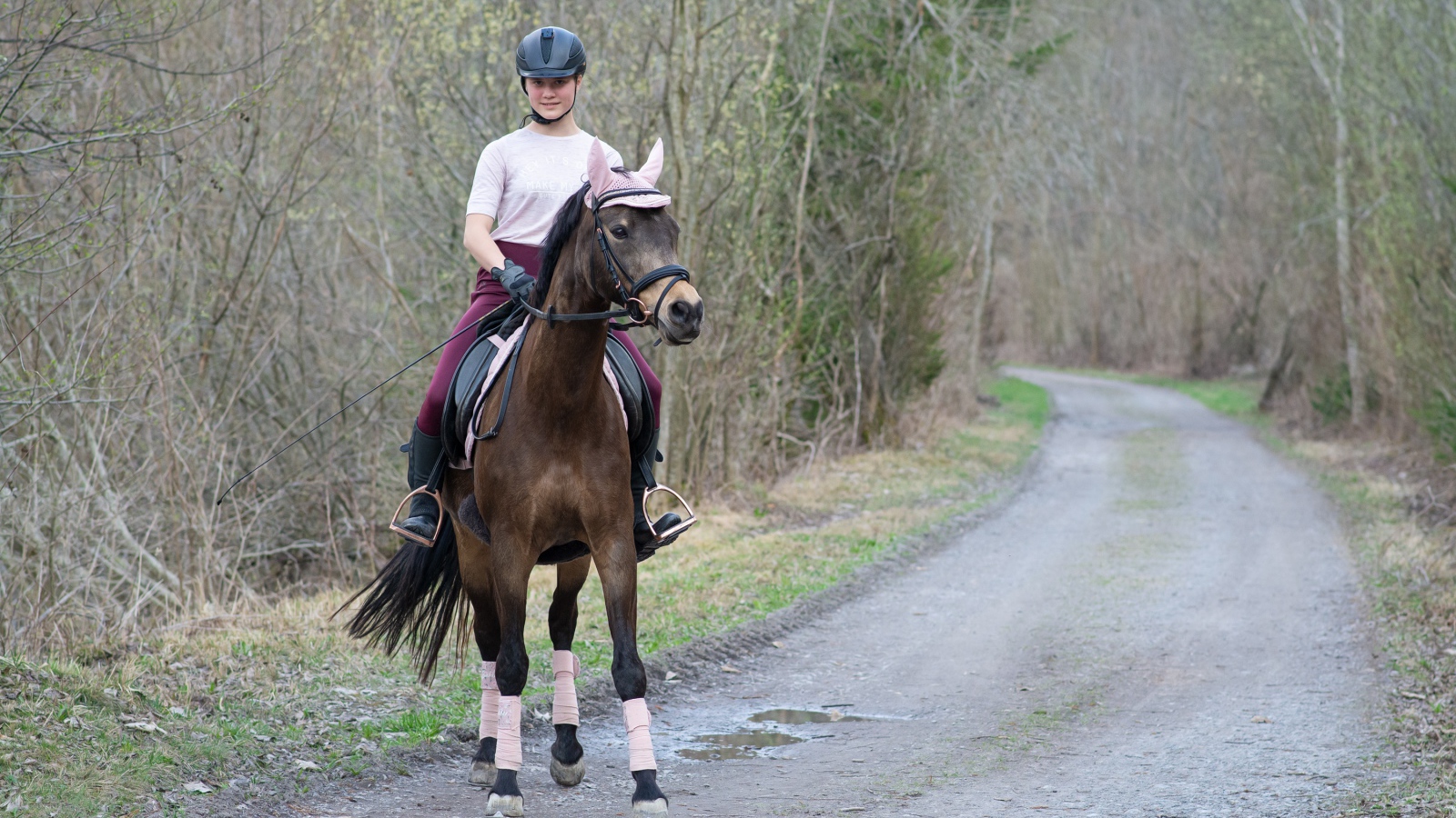 Молодая девушка катается на лошади 