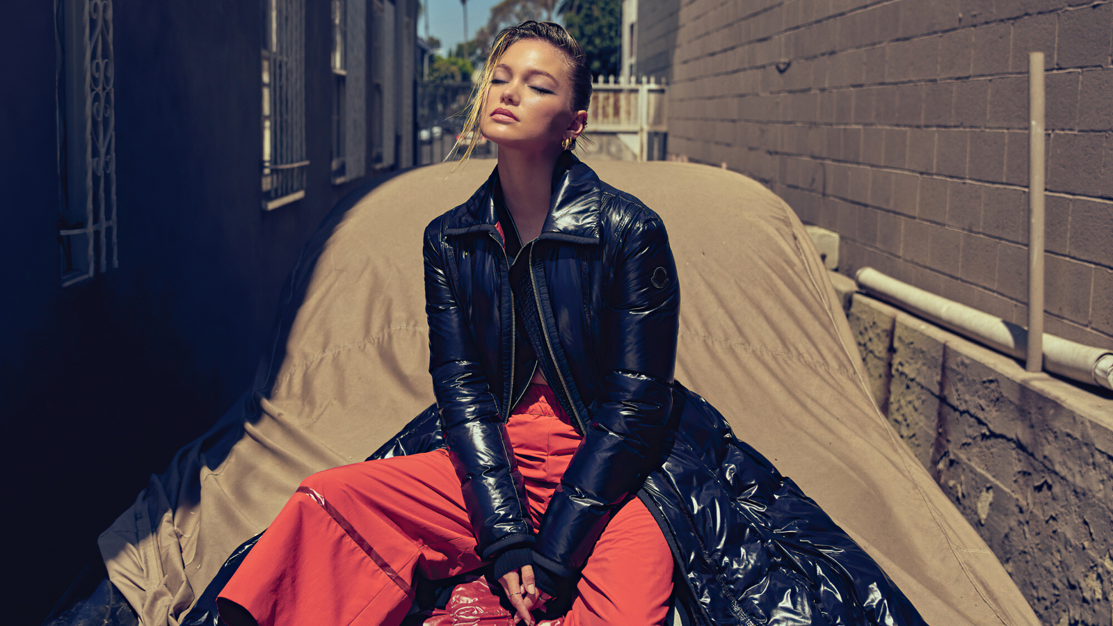 Актриса Оливия Холт в черной куртке сидит на машине