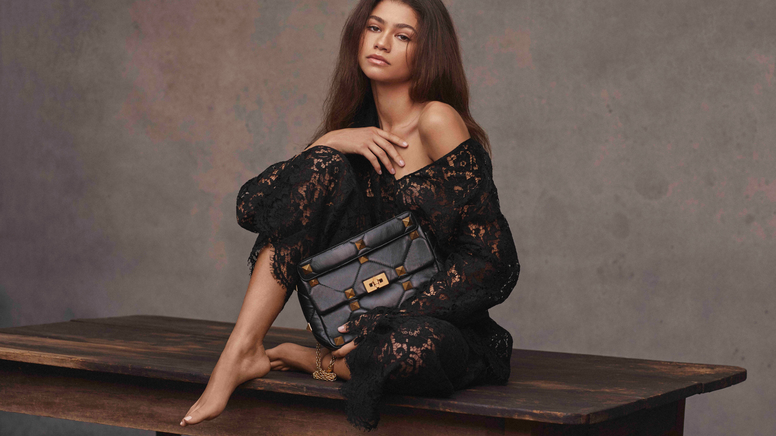 Американская актриса и певица Зендая в черном платье на столе