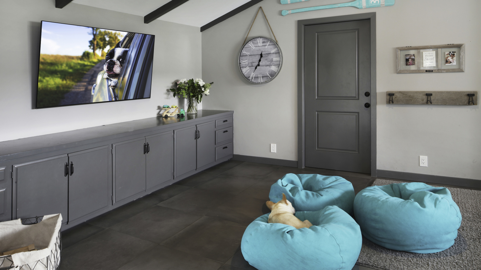 Голубые кресла в комнате с большим телевизором 