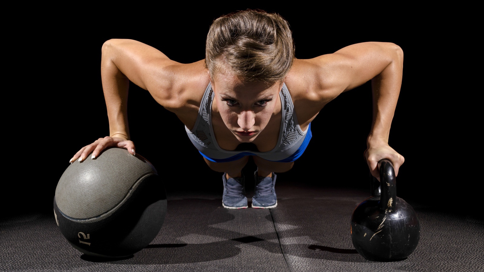 Девушка отжимается с гирями