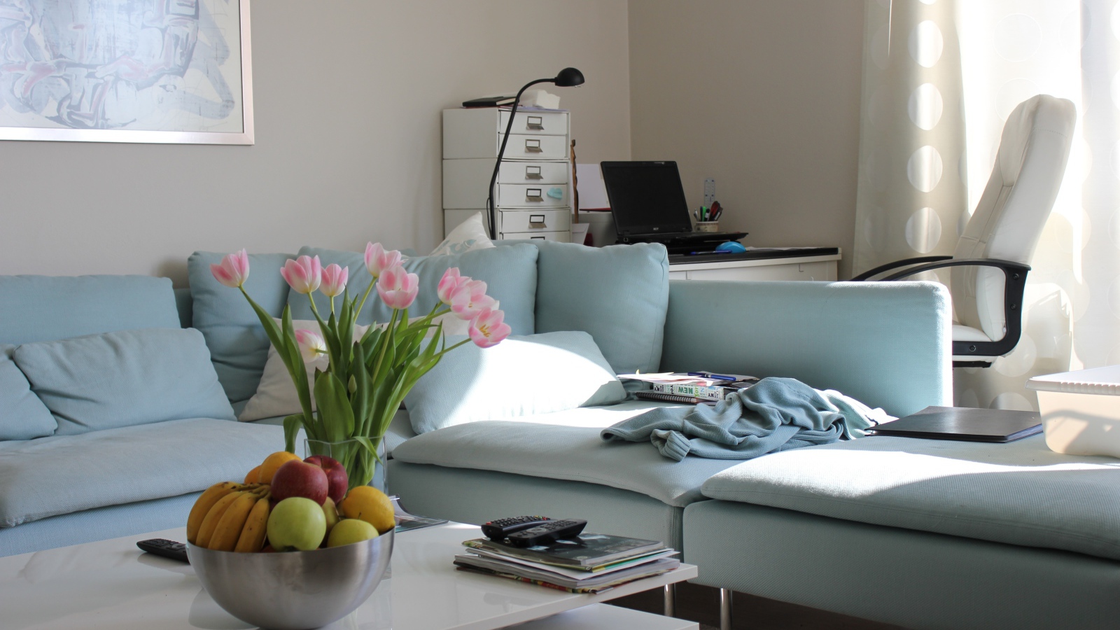 Большой серый диван в гостиной со столом 