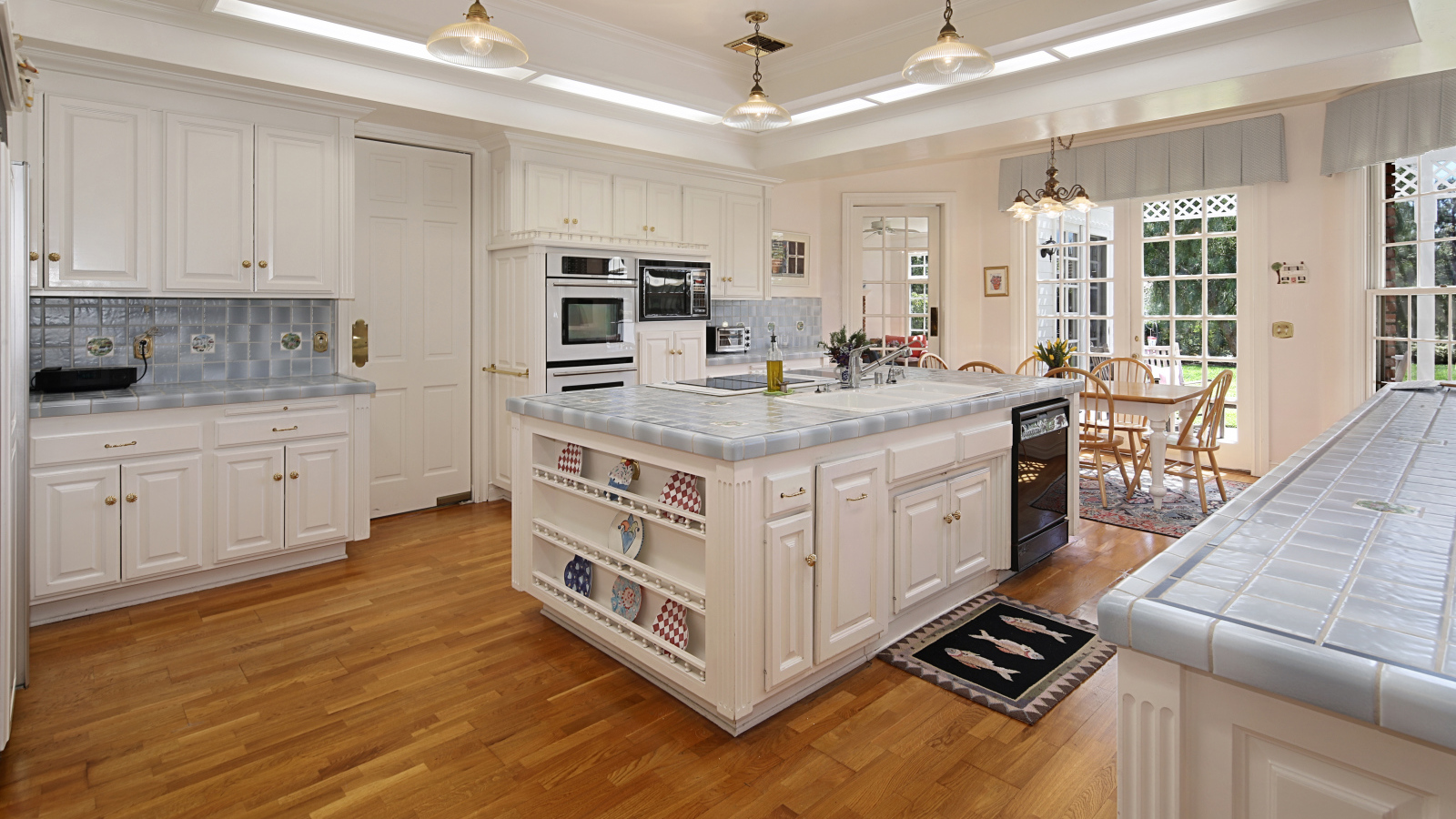 Белые стены и мебель на просторной современной кухне 