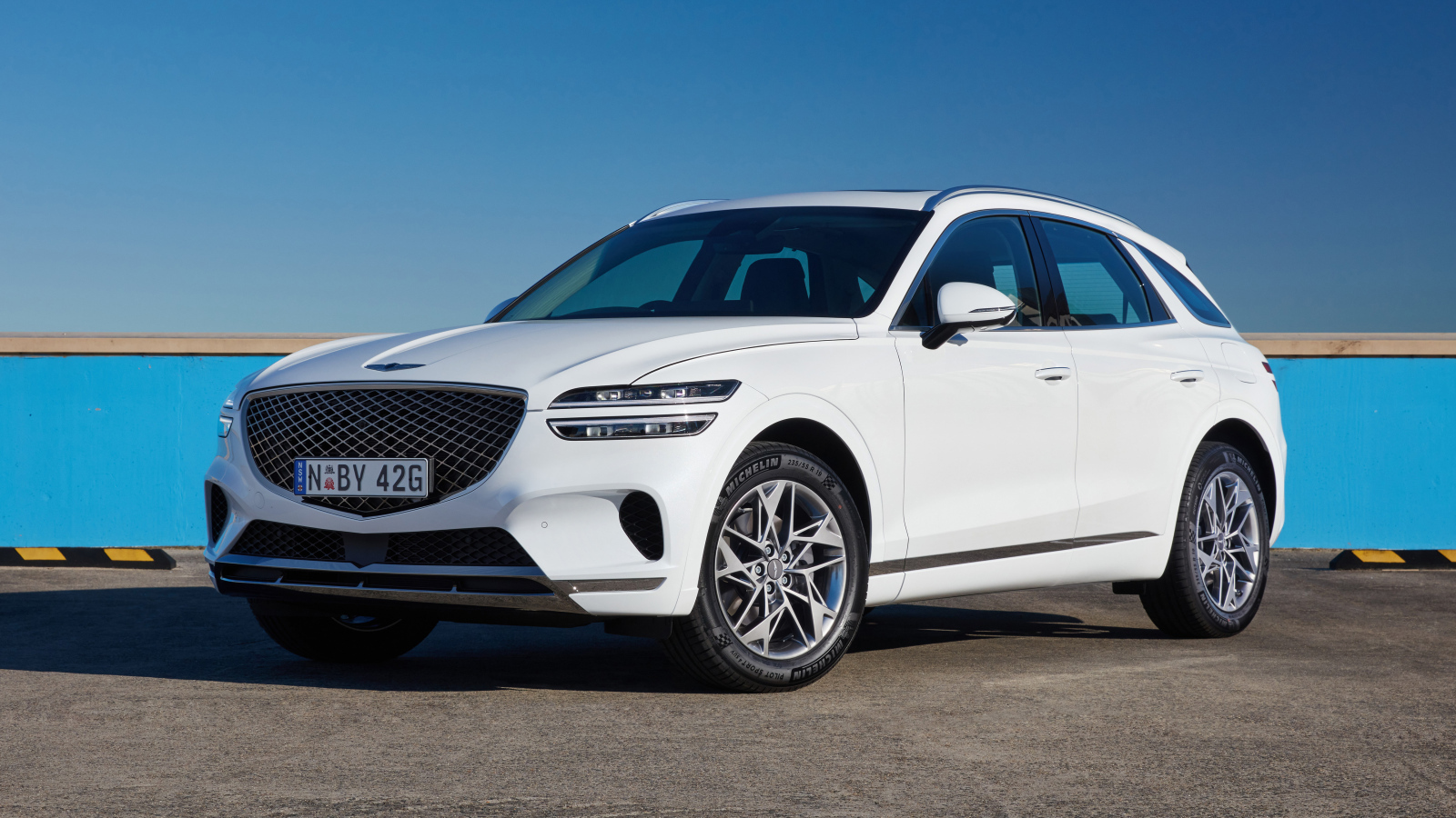 Белый Genesis GV70 2.5T на фоне неба 