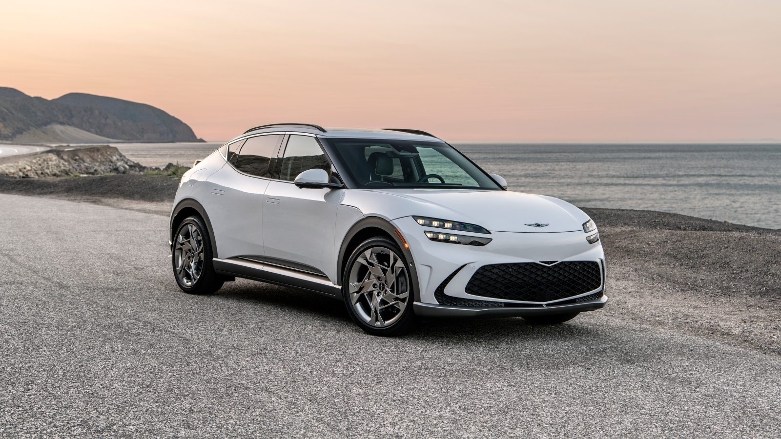 Белый автомобиль Genesis GV60, 2023 года на пляже