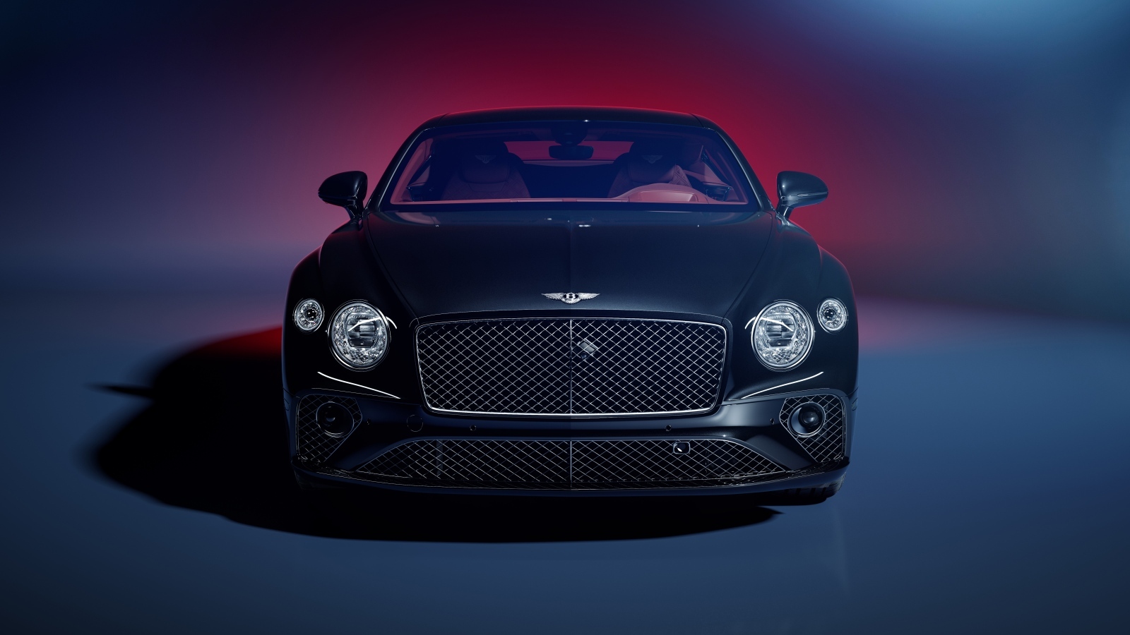 Вид спереди на автомобиль Bentley Continental GT на синем фоне