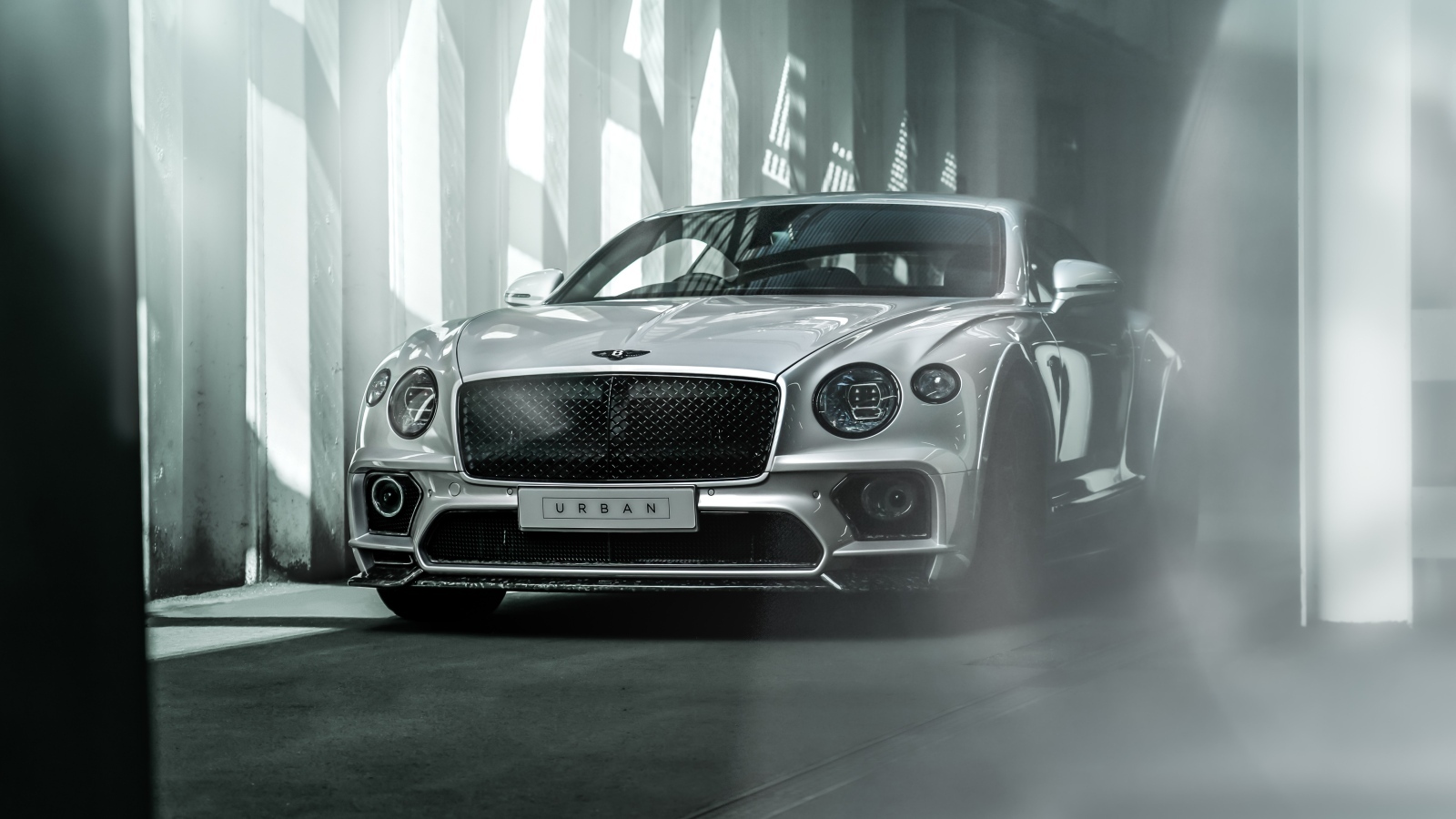Серебристый автомобиль Bentley Continental GT в здании
