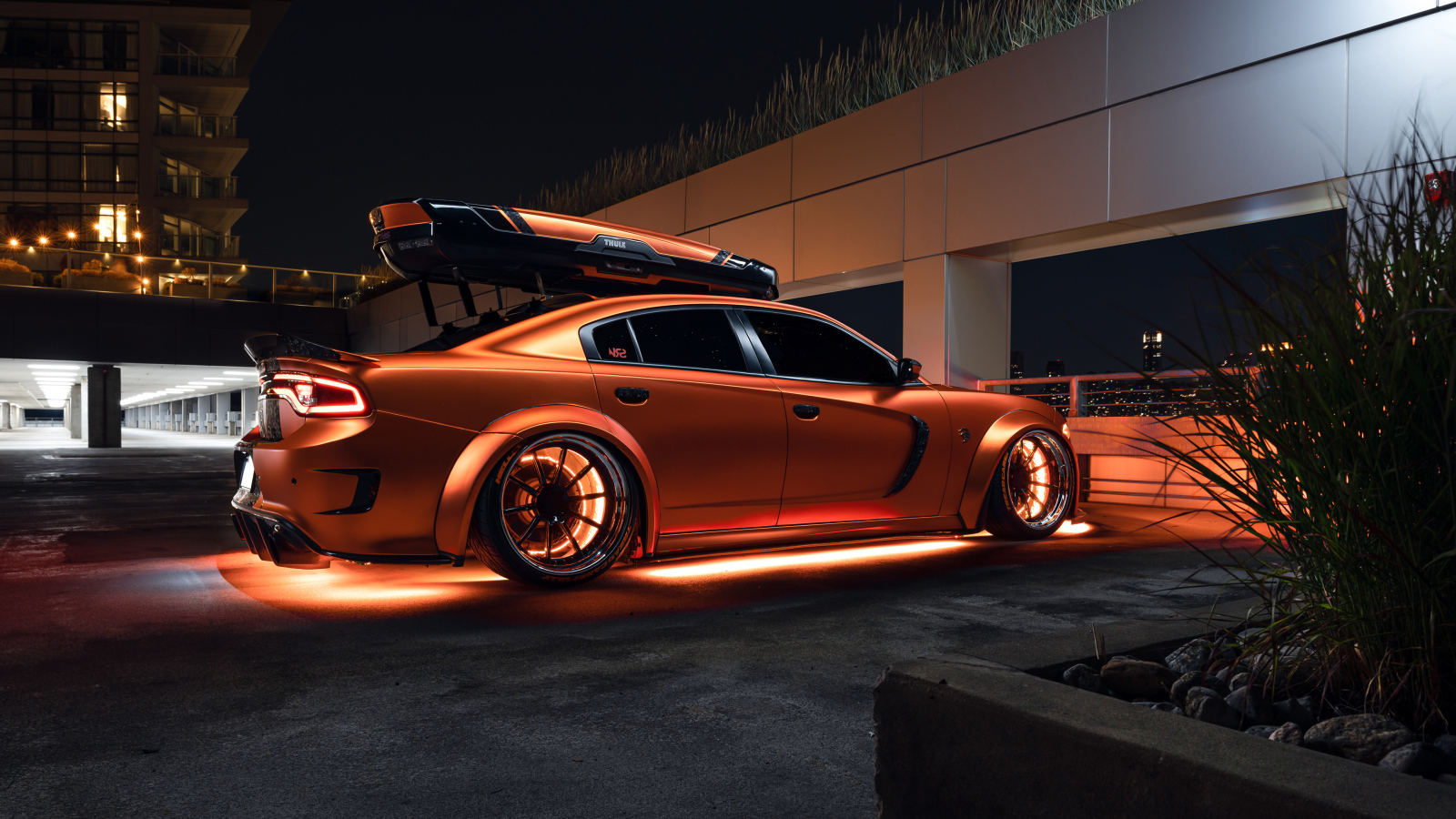 Оранжевый автомобиль Dodge Charger стоит у гаража
