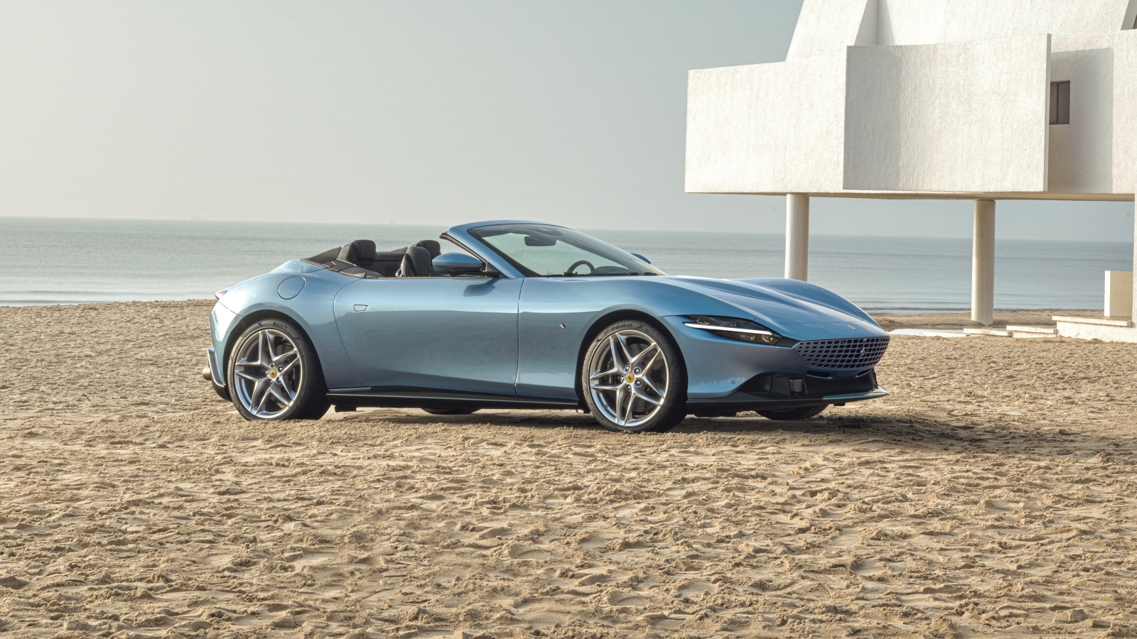 Автомобиль Ferrari Roma Spider 2023 года стоит на песке