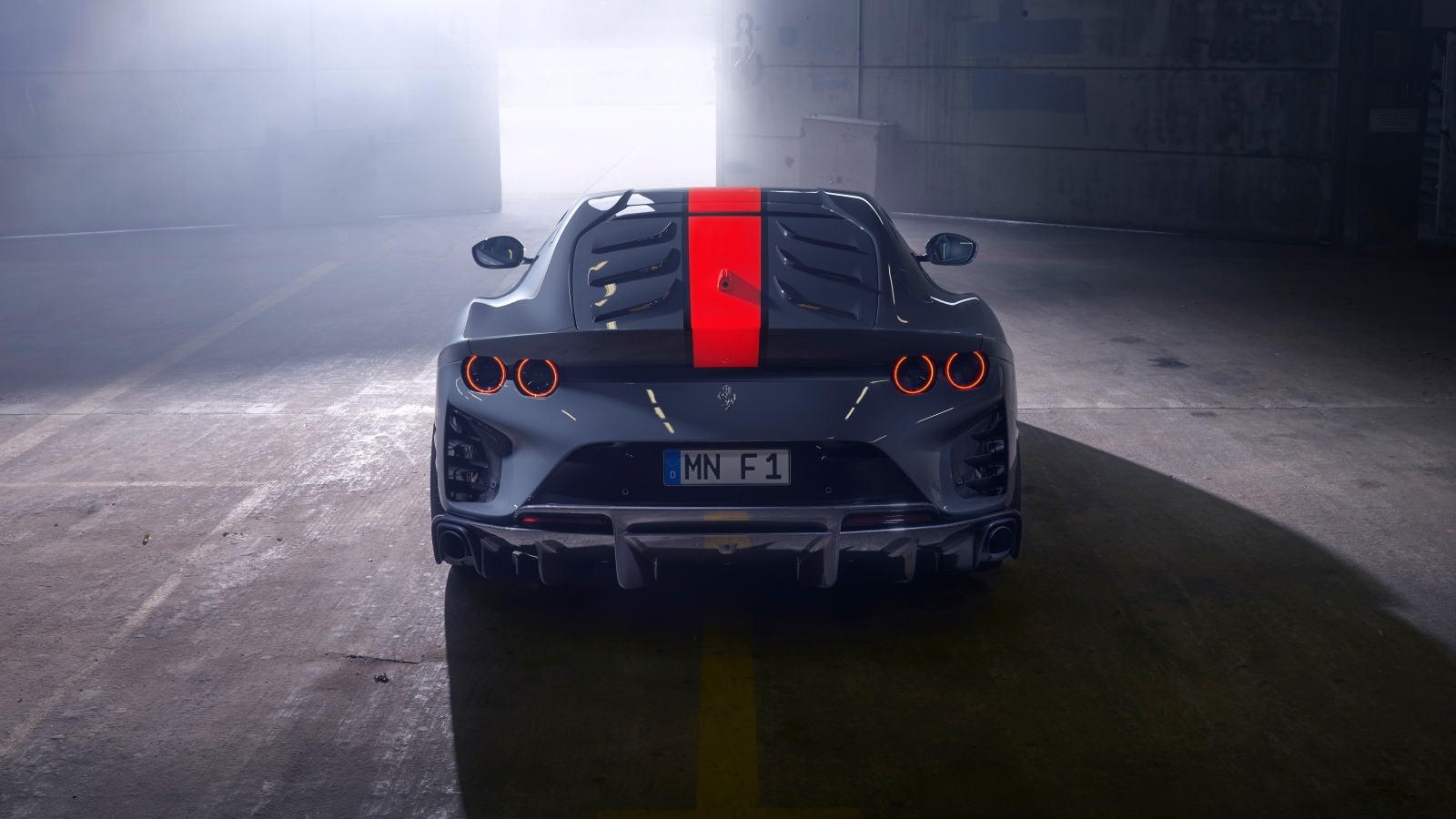 Серый спортивный автомобиль Ferrari 812 вид сзади