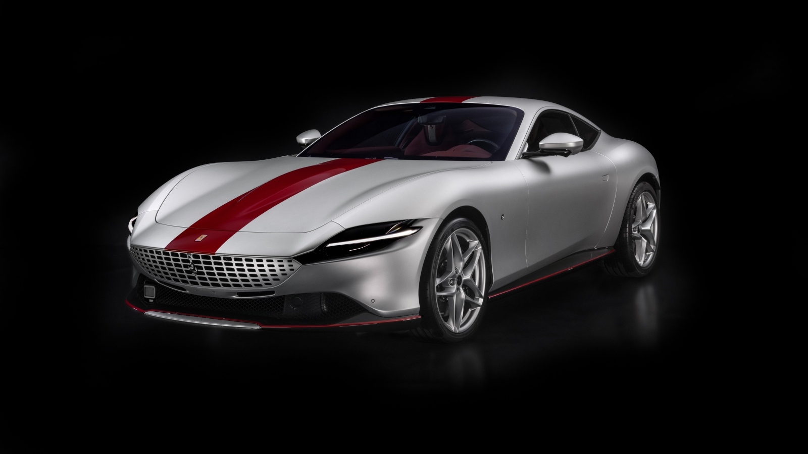 Серебристый Ferrari Roma 30th Anniversary 2023 года на черном фоне