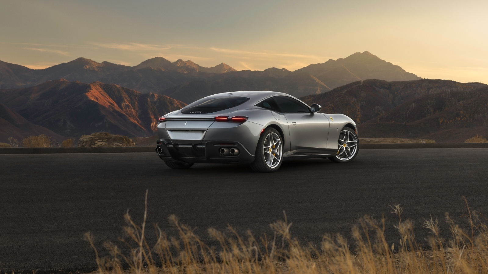 Серебристый автомобиль Ferrari Roma вид сзади