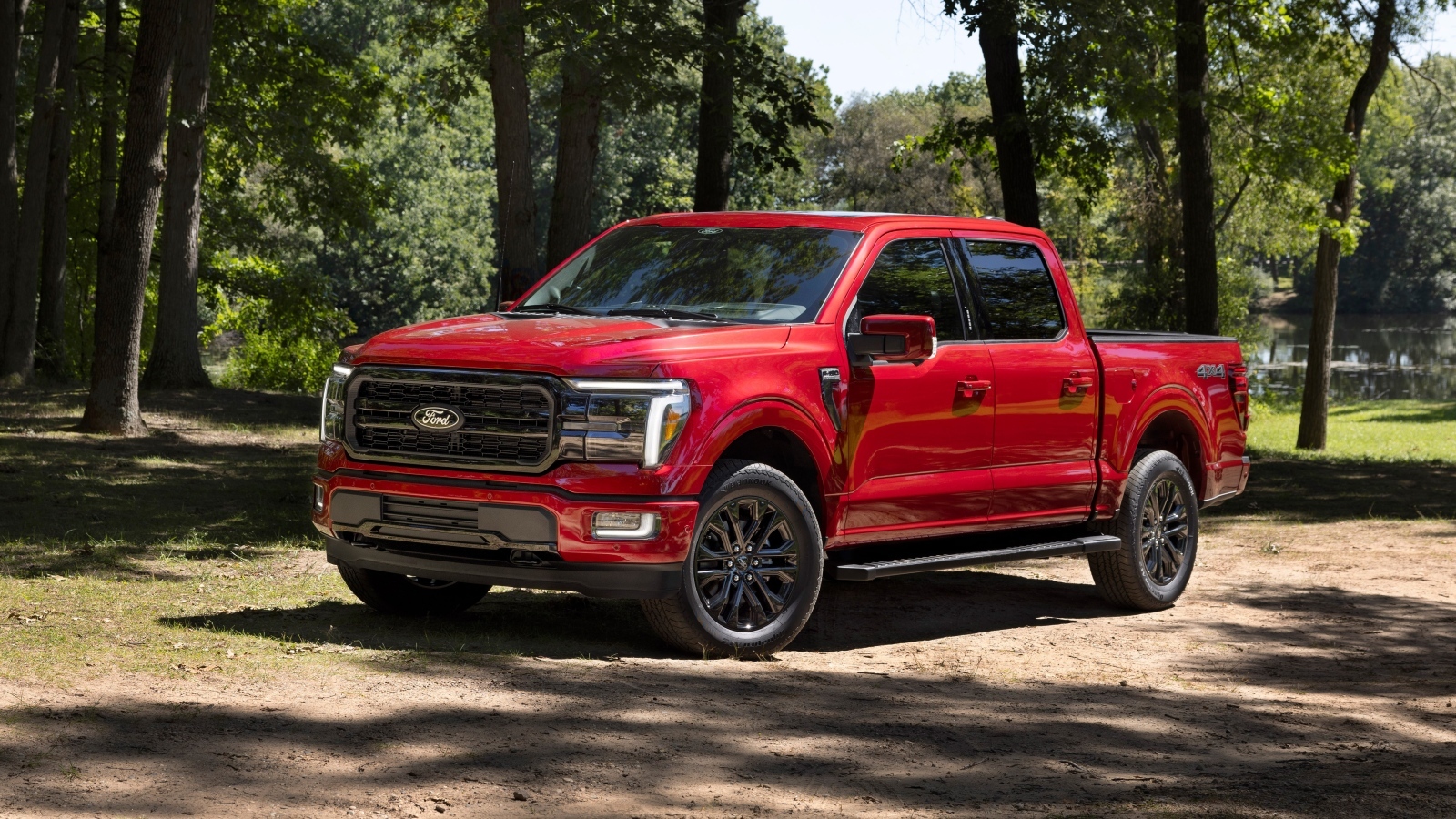 Большой красный Ford F-150 Lariat 2024 года в лесу
