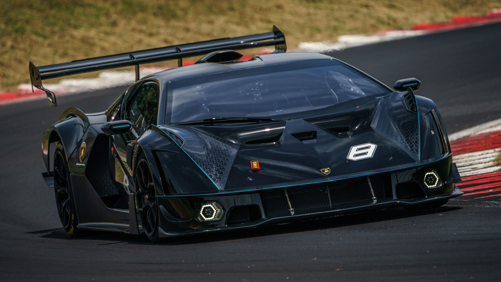 Черный спортивный Lamborghini Essenza SCV12 на гоночной трассе 