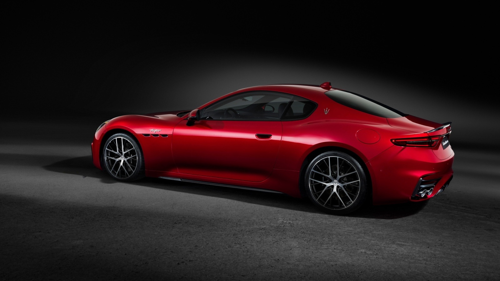 Красный автомобиль Maserati GranTurismo Trofeo 2023 на сером фоне