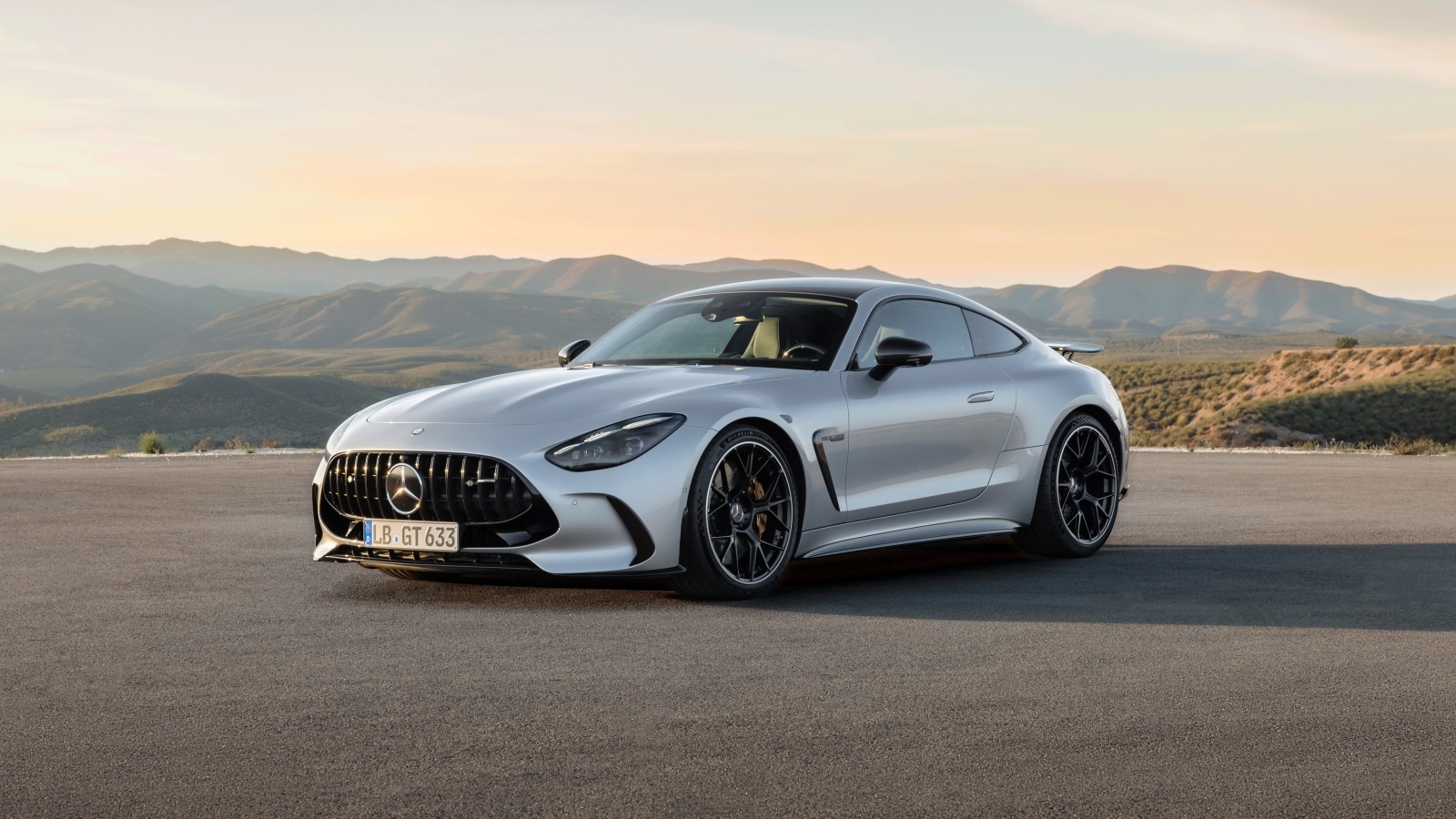 Серебристый автомобиль Mercedes-AMG GT 63 4MATIC+ 2023 года на фоне гор