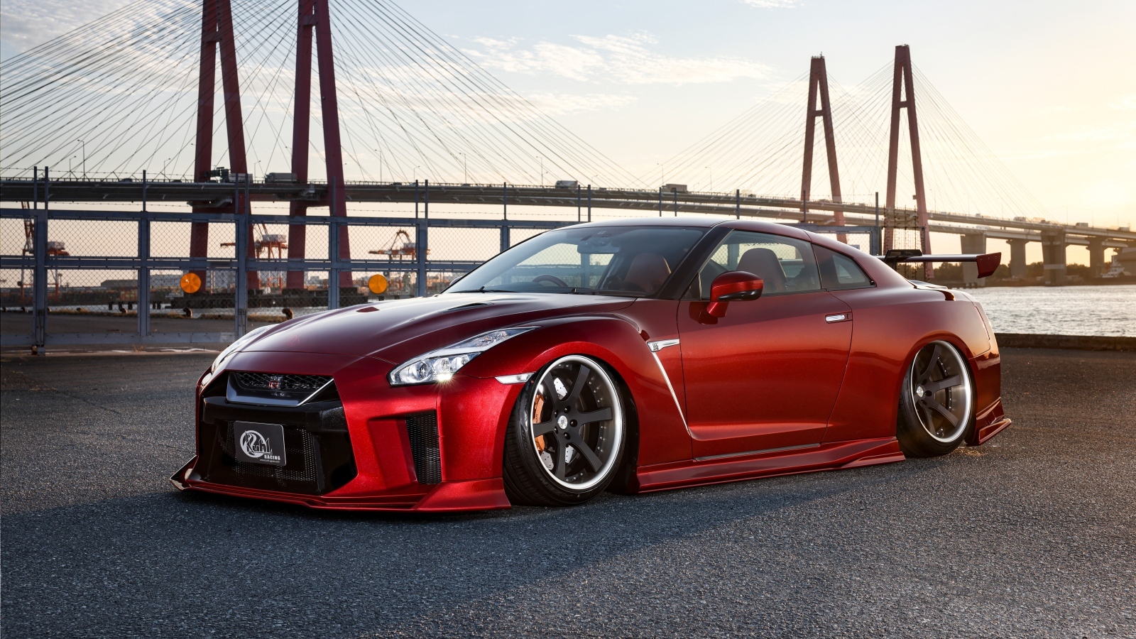 Красный автомобиль Nissan GTR 35R на фоне моста