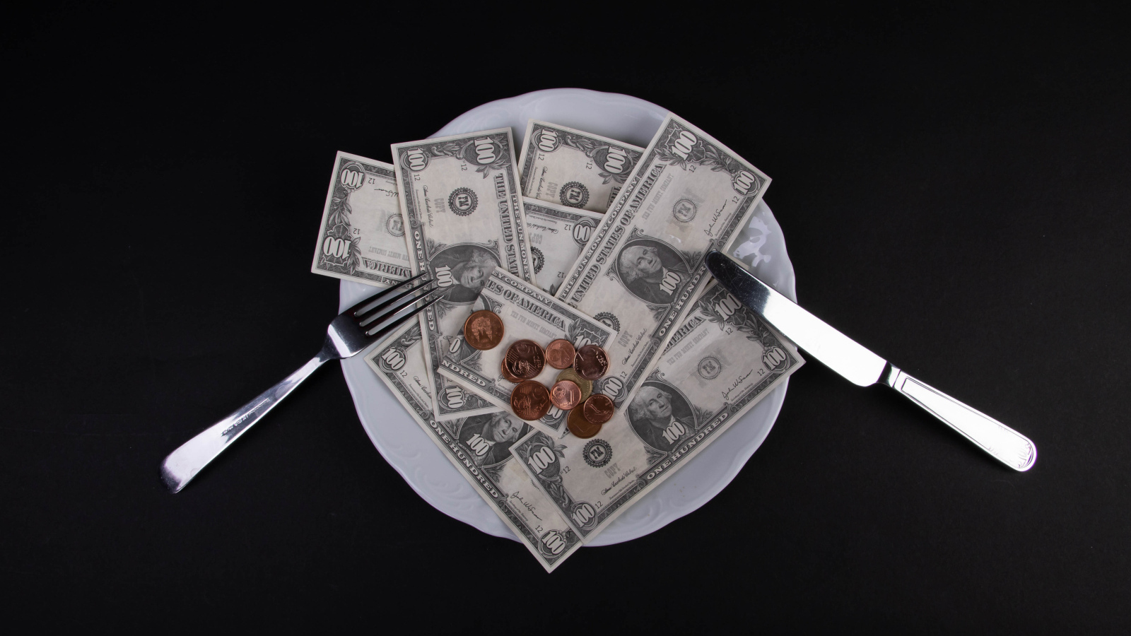 Тарелка с долларами на черном фоне