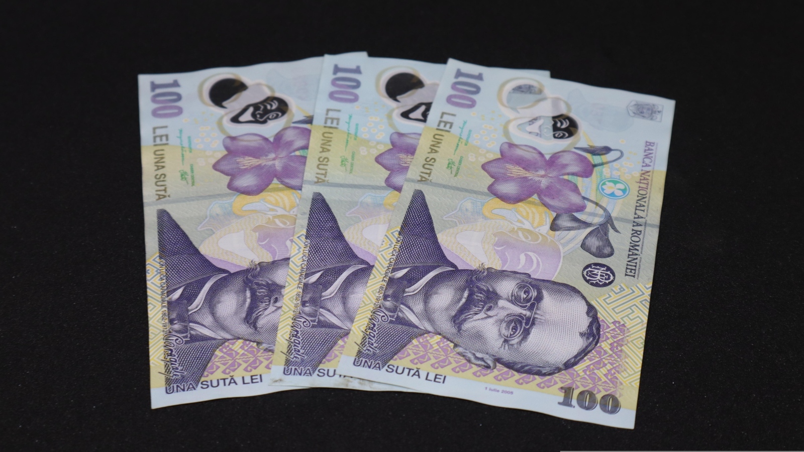 Три купюры на черном фоне