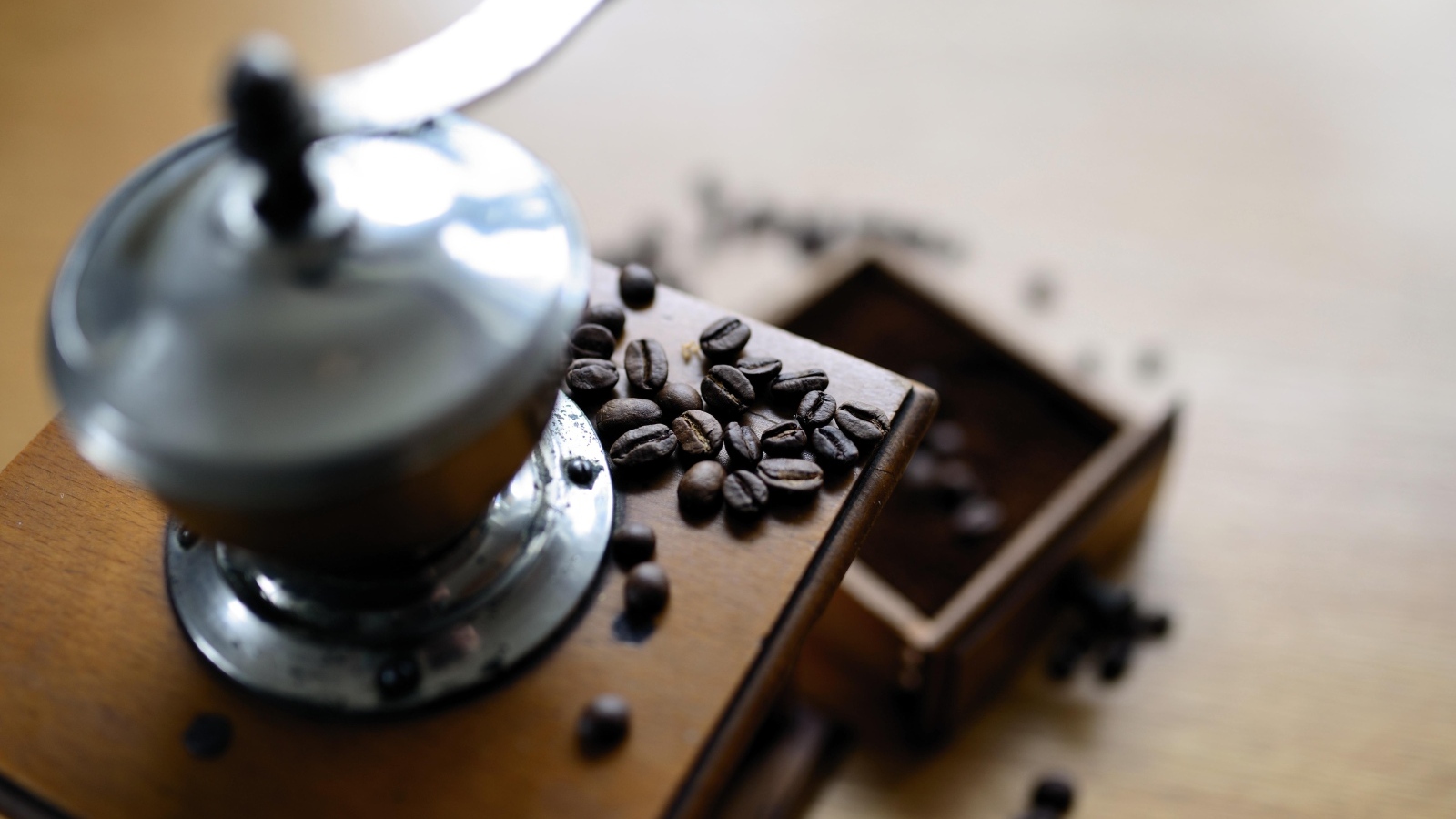 Кофемолка на столе с зернами