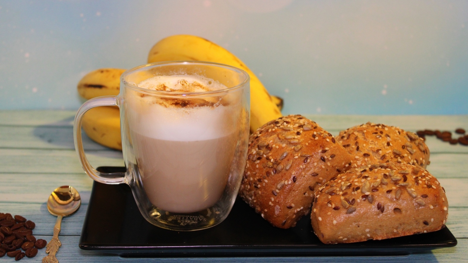 Чашка какао на столе с булочками и бананами