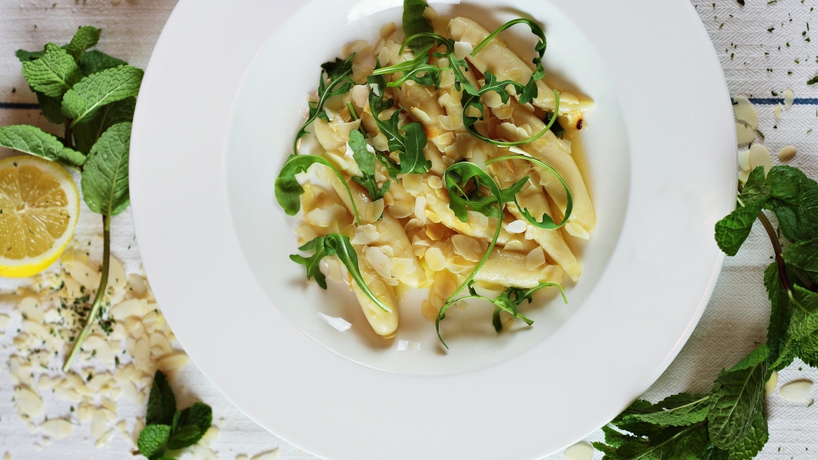 Блюдо с листьями рукколы в большой белой тарелке